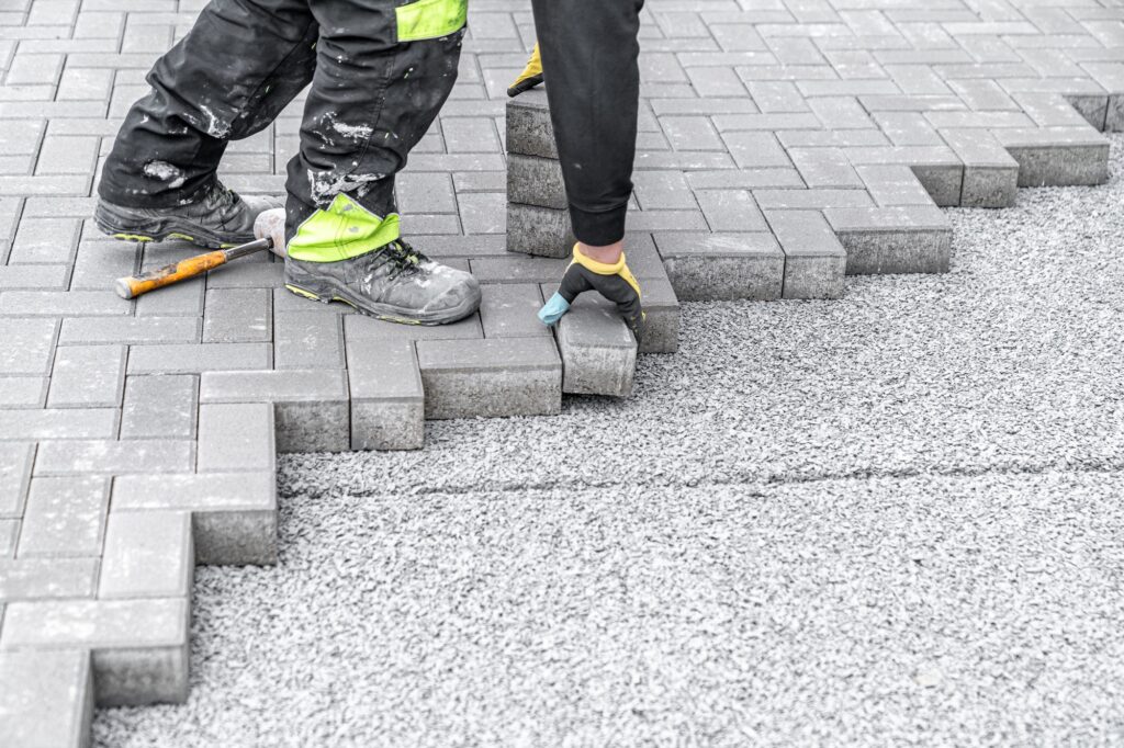 laying interlocking pavers during the construction of sidewalks and roads